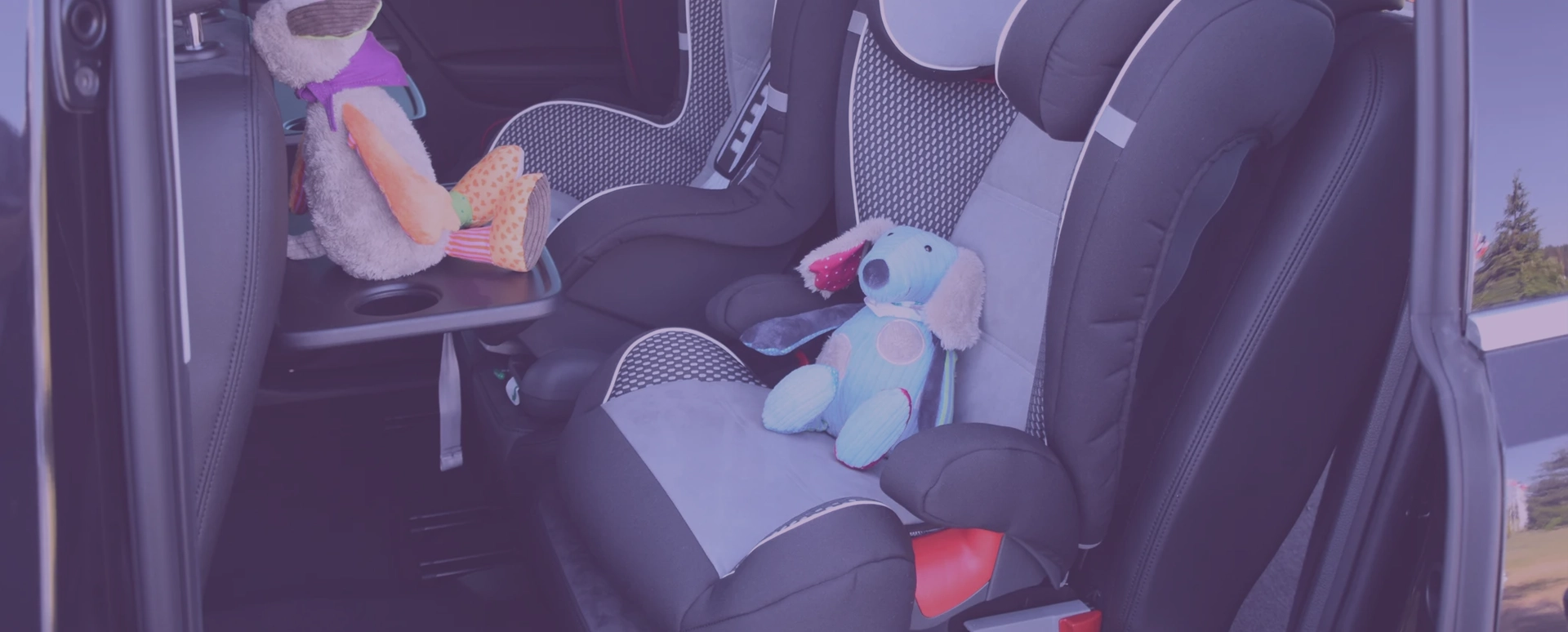 Two child seats in the car with toys